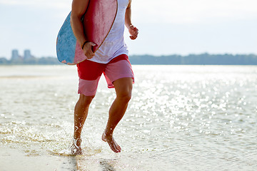 Image showing happy young man with skimboard on summer beach