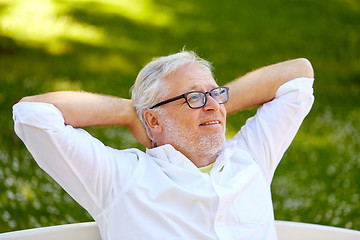 Image showing happy senior man in glasses sitting at summer park