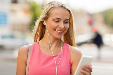 Image showing happy young woman with smartphone and earphones