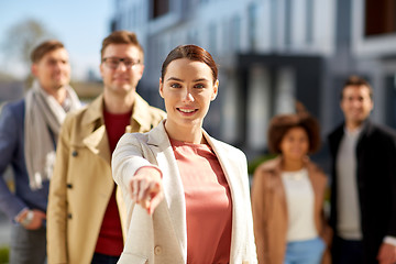 Image showing happy smiling woman pointing finger at you 