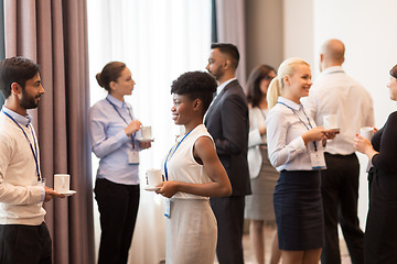 Image showing business people with conference badges and coffee