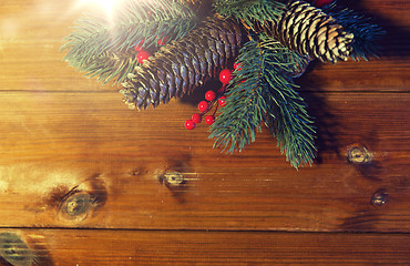 Image showing close up of fir branch with cones on wooden table