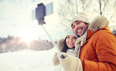Image showing happy couple taking selfie by smartphone in winter