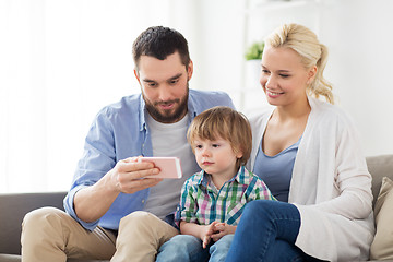 Image showing happy family with smartphone at home