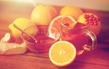 Image showing tea with honey, lemon and ginger on wood