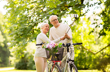 Image showing senior couple with bicycles taking selfie at park