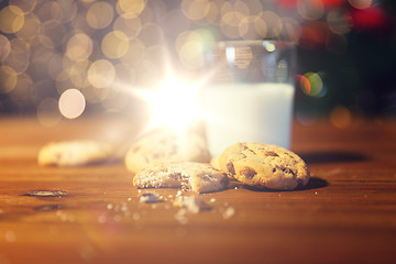 Image showing close up of cookies and milk over christmas lights