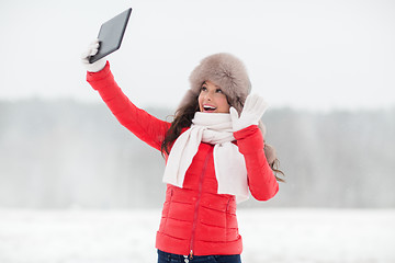 Image showing woman in winter fur hat with tablet pc outdoors