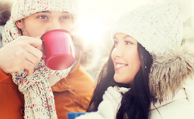 Image showing happy couple with tea cups over winter landscape