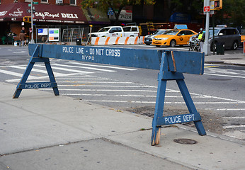 Image showing Police line do not cross wooden barrier on a sidewalk