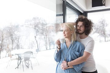 Image showing young couple enjoying morning coffee by the window