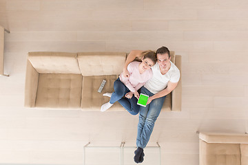 Image showing young couple in living room using tablet top view