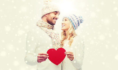 Image showing smiling couple in winter clothes with red heart