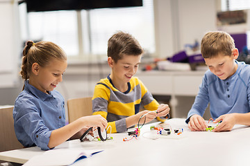 Image showing happy children building robots at robotics school