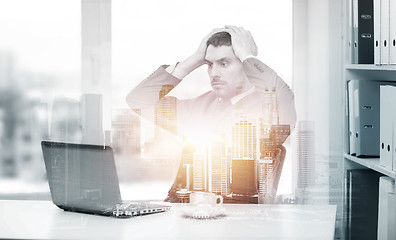 Image showing stressing businessman with laptop at office