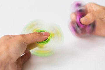 Image showing close up of hands playing with fidget spinners