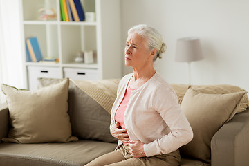 Image showing senior woman suffering from stomach ache at home