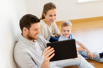 Image showing happy family with tablet pc moving to new home