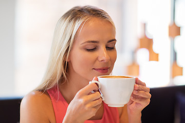 Image showing close up of woman drinking coffee at restaurant