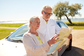 Image showing senior couple at car looking for location on map