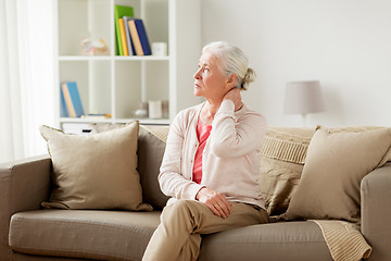 Image showing senior woman suffering from neck pain at home