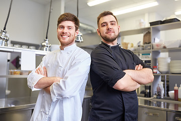 Image showing happy smiling chef and cook at restaurant kitchen