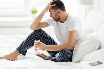 Image showing man in bed with glass of water at home