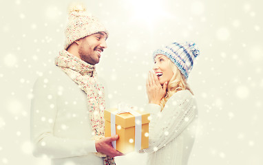 Image showing smiling couple in winter clothes with gift box