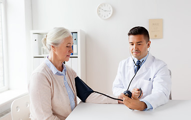 Image showing senior woman and doctor with tonometer at hospital