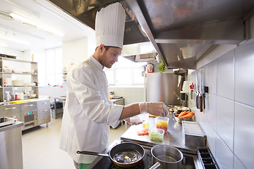 Image showing happy male chef cooking food at restaurant kitchen