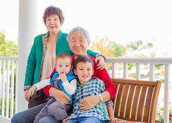 Image showing Senior Adult Chinese Couple Sitting With Their Mixed Race Grandc