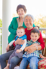 Image showing Senior Adult Chinese Couple Sitting With Their Mixed Race Grandc