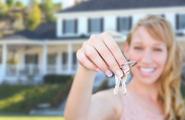 Image showing Excited Female Holding House Keys in Front of Nice New Home.