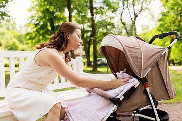 Image showing happy mother with child in stroller at summer park