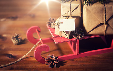 Image showing close up of christmas gifts with note on sleigh