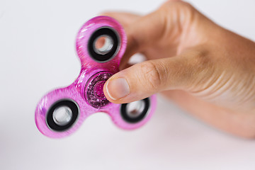 Image showing close up of hand playing with fidget spinner