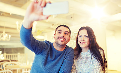 Image showing couple taking smartphone selfie at cafe restaurant