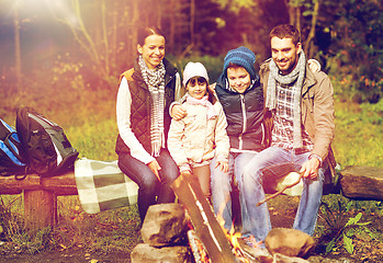 Image showing happy family sitting on bench at camp fire