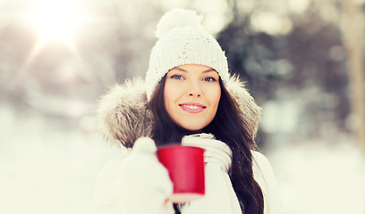 Image showing happy young woman with tea cup outdoors in winter