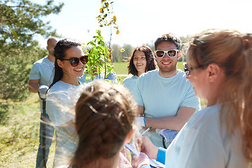 Image showing group of volunteers with tree seedlings in park