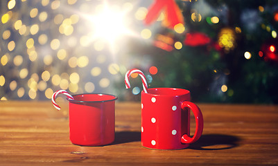 Image showing christmas candy canes and cups on wooden table