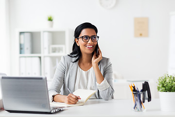 Image showing businesswoman calling on smartphone at office