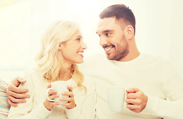 Image showing happy couple with cups drinking tea at home