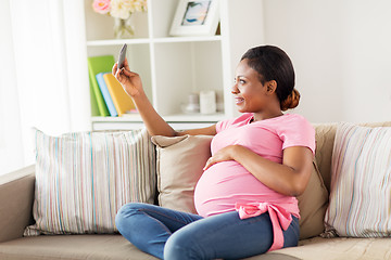 Image showing pregnant woman taking smartphone selfie at home