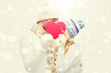 Image showing smiling couple in winter clothes with red heart