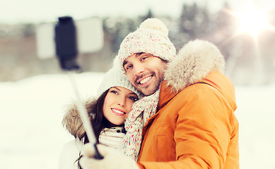 Image showing happy couple taking selfie by smartphone in winter