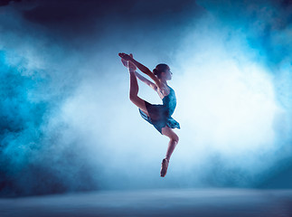 Image showing Beautiful young ballet dancer jumping on a lilac background.