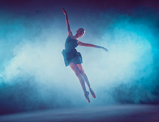 Image showing Beautiful young ballet dancer jumping on a lilac background.