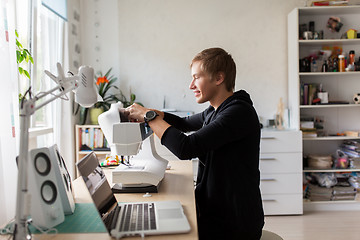 Image showing tailor adjusting sewing machine at studio workshop