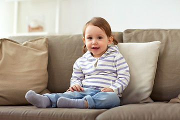 Image showing happy smiling baby girl sitting on sofa at home